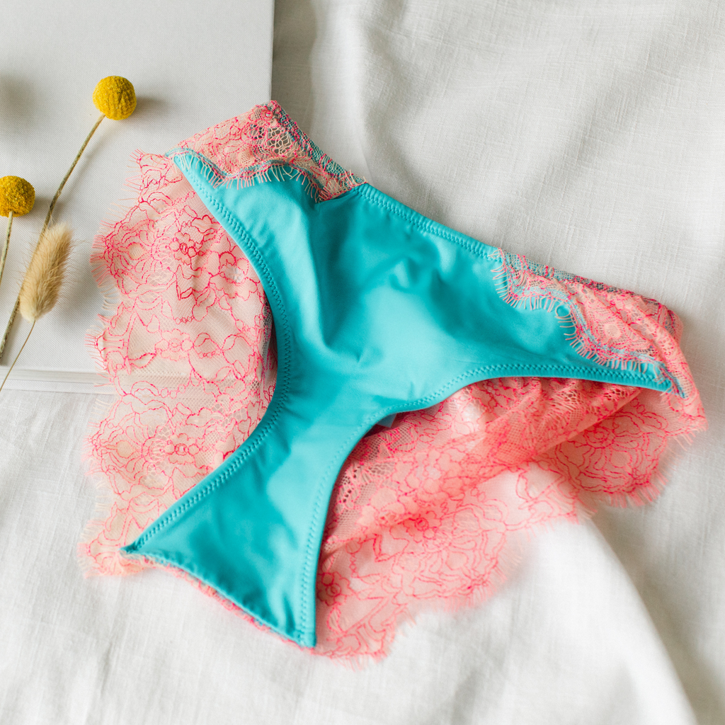 Our Idol blue brazilian knickers lying on some white linen - Valiant Lingerie
